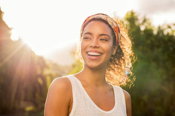 Woman smiling under the rays of sunlight